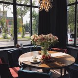 Большие окна и красивые люстры делают большой зал ресторана очень уютным. 